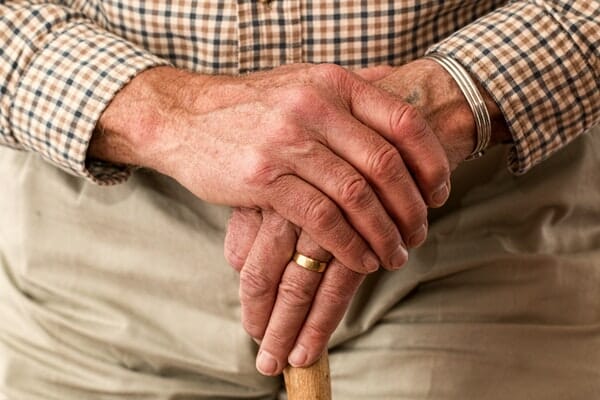 Elderly man holding a cane after being a victim of abuse at an assisted living facility